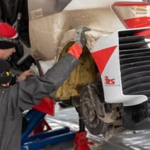 1. Bir otomobilin kaputu açık halde motor bölmesi kontrol edilirken çekilmiş bir fotoğraf.