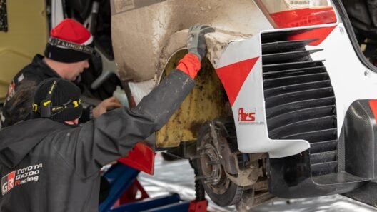 1. Bir otomobilin kaputu açık halde motor bölmesi kontrol edilirken çekilmiş bir fotoğraf.