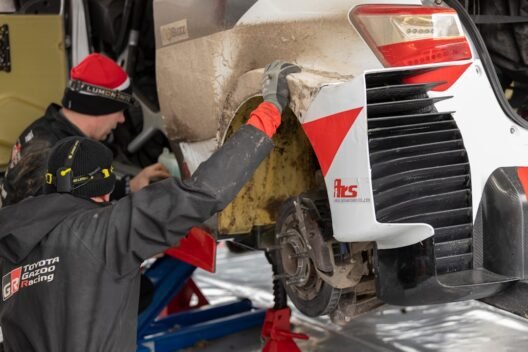 1. Bir otomobilin kaputu açık halde motor bölmesi kontrol edilirken çekilmiş bir fotoğraf.