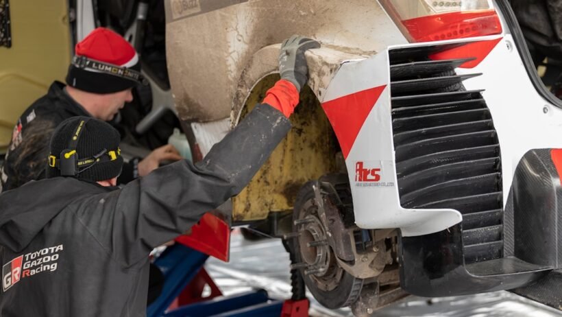 1. Bir otomobilin kaputu açık halde motor bölmesi kontrol edilirken çekilmiş bir fotoğraf.